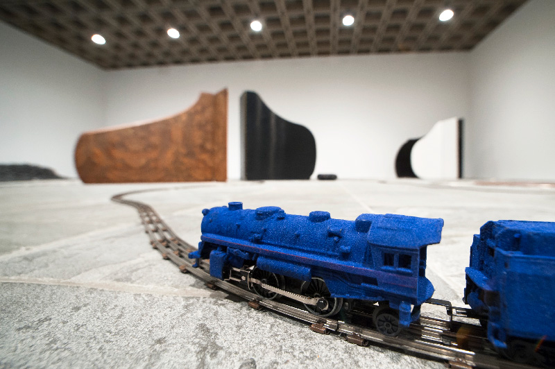 Un train bleu sur rails installé dans la salle d'exposition du Whitney Museum of American Art, New York par David Hammons
