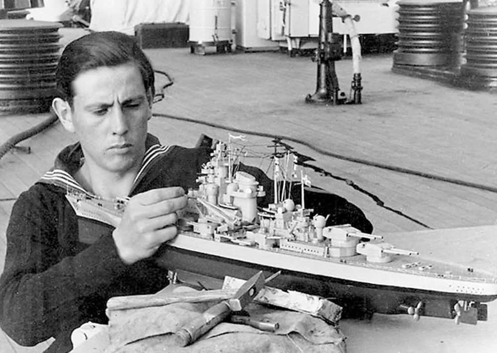 Soldat russe jouant avec une maquette du Tirpitz sur le pont du bateau