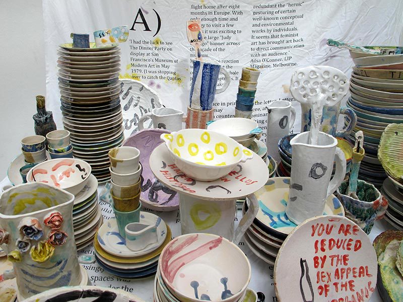 Plusieurs objets en céramique posés sur une table : assiettes, bols, tasses, pichets font partie de l'oeuvre Keramikos de l'artiste Natsuko Uchino